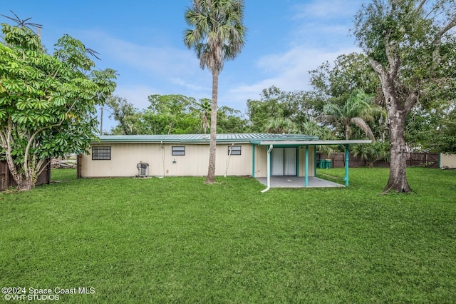 back of property with a patio area and a yard