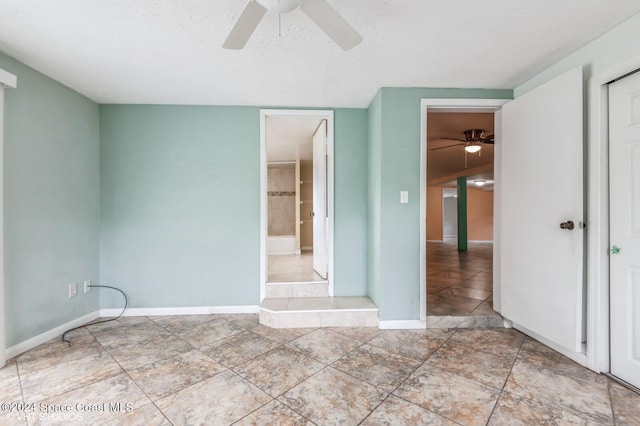 tiled spare room with a textured ceiling and ceiling fan