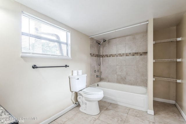 bathroom featuring tiled shower / bath combo, toilet, and tile patterned flooring