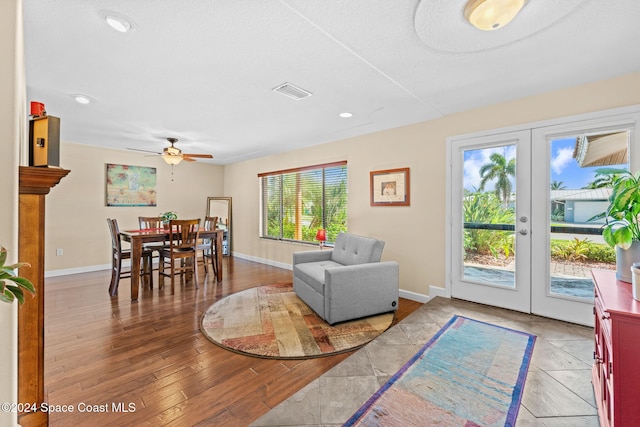 living area with french doors, hardwood / wood-style flooring, a textured ceiling, and ceiling fan