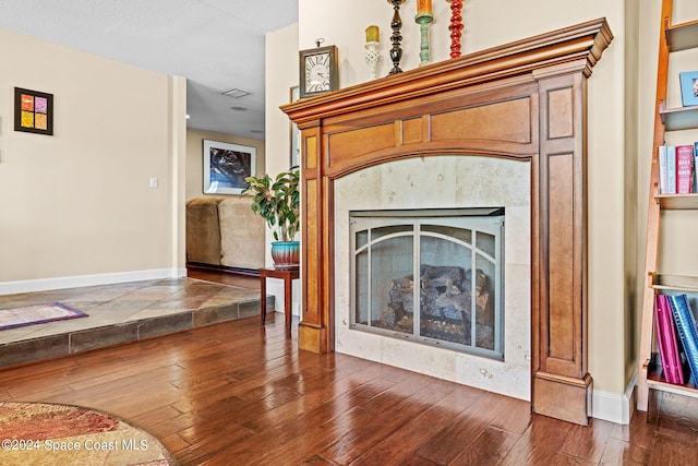 details with hardwood / wood-style flooring, a fireplace, and a textured ceiling