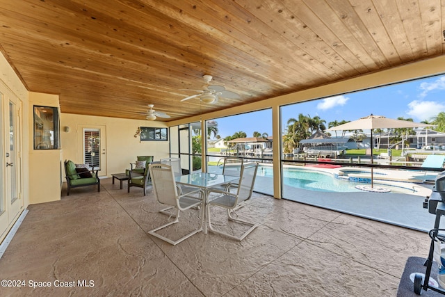 sunroom with wood ceiling, a pool, and ceiling fan