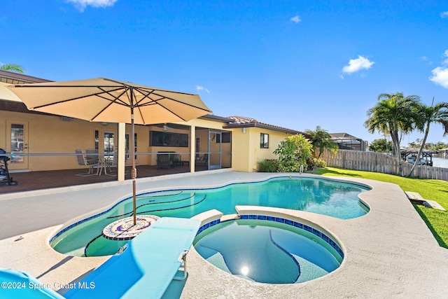 view of swimming pool featuring an in ground hot tub and a patio