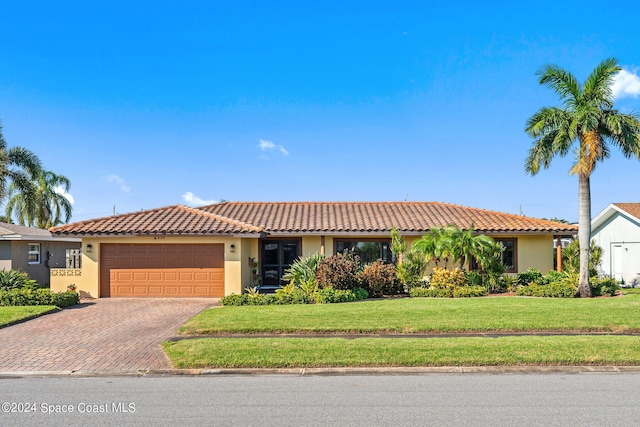 view of front of property featuring a garage and a front lawn