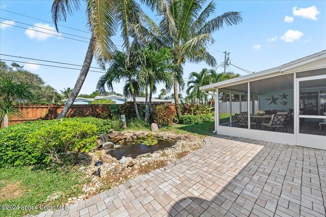 view of yard featuring a sunroom and a patio