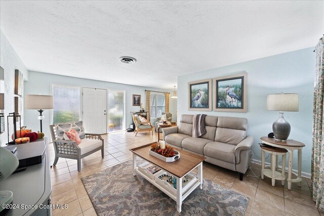 tiled living room featuring a textured ceiling