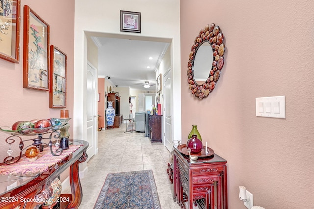 hallway with ornamental molding and light tile patterned flooring