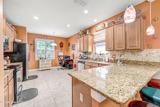 kitchen with kitchen peninsula, hanging light fixtures, appliances with stainless steel finishes, and a kitchen breakfast bar