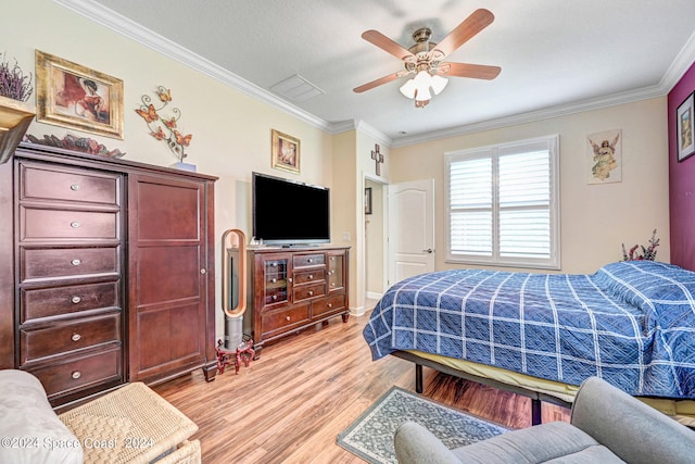 bedroom with light wood finished floors, ornamental molding, visible vents, and a ceiling fan