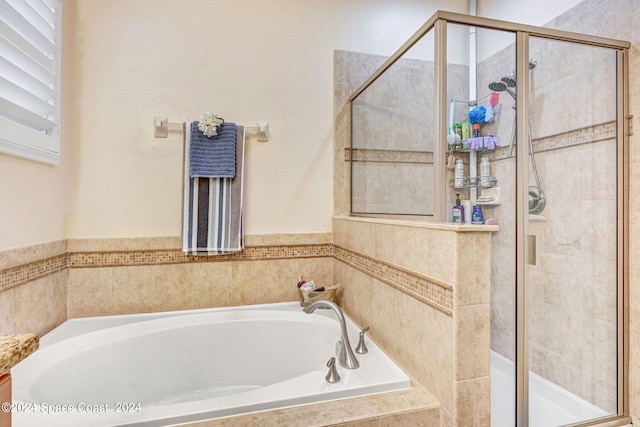 full bathroom featuring a stall shower and a garden tub