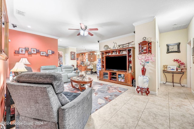 living area featuring light tile patterned floors, ceiling fan, visible vents, baseboards, and ornamental molding