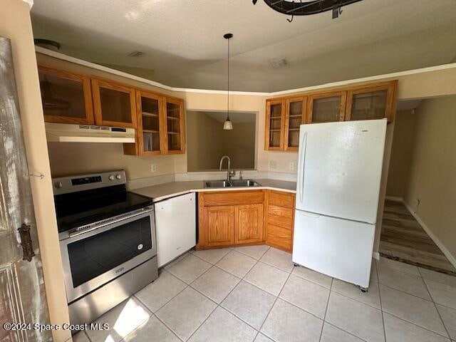 kitchen featuring light tile patterned floors, white appliances, sink, and decorative light fixtures