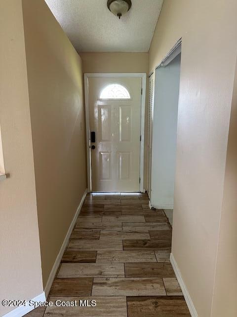 doorway featuring hardwood / wood-style flooring and a textured ceiling