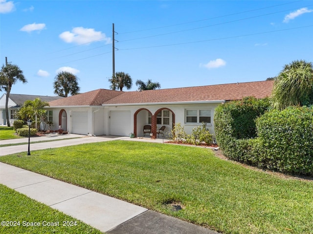 ranch-style home with a garage and a front lawn