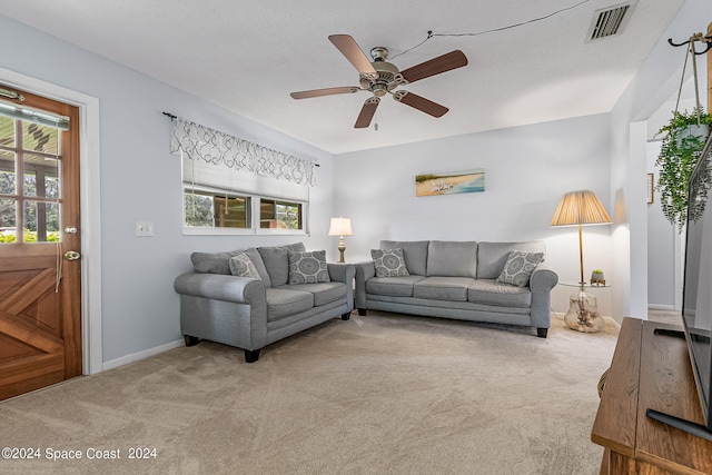 living room featuring ceiling fan, light colored carpet, and a wealth of natural light