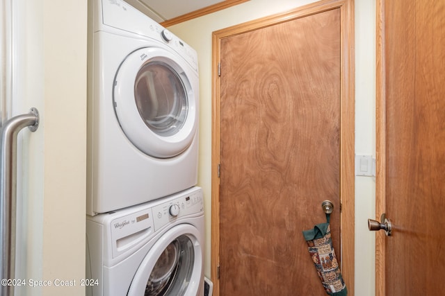 washroom with stacked washer / drying machine and ornamental molding