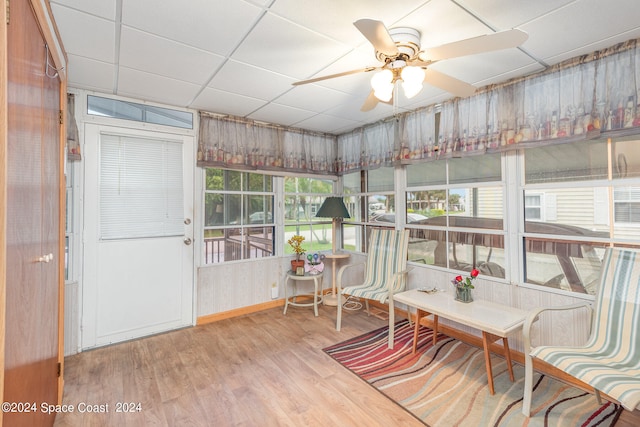 sunroom / solarium with ceiling fan and a drop ceiling