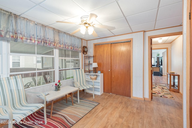 interior space featuring ceiling fan, hardwood / wood-style flooring, and a drop ceiling