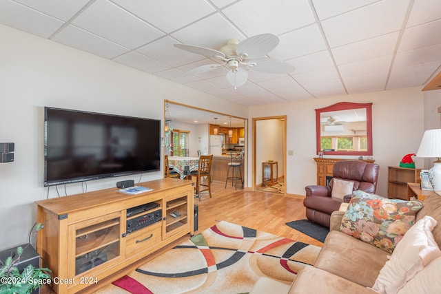 living room featuring wood-type flooring, a drop ceiling, and ceiling fan