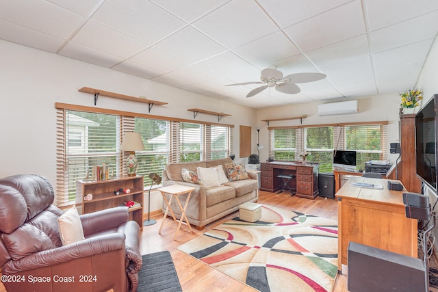 living room featuring ceiling fan, light hardwood / wood-style flooring, and a wall mounted AC