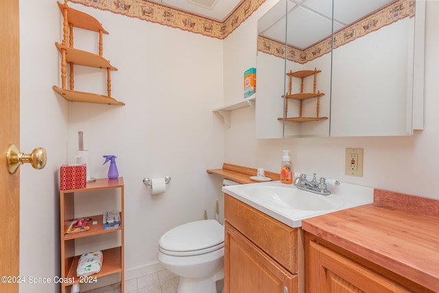 bathroom with tile patterned flooring, vanity, and toilet