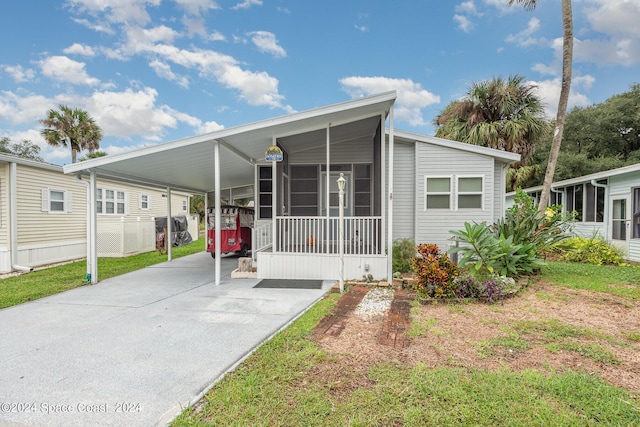 manufactured / mobile home with a carport and a sunroom