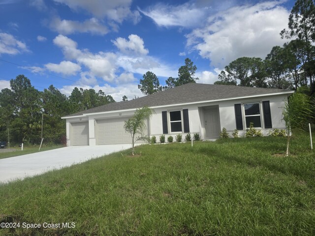 2755 Fleming Ave SW, Palm Bay, FL 32908 - ranch-style home featuring an attached garage, a front lawn, stucco siding, and driveway