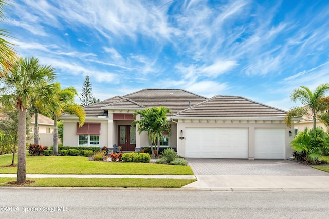 view of front of property with a front yard and a garage