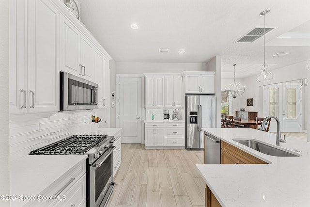 kitchen featuring light hardwood / wood-style flooring, white cabinets, sink, and premium appliances