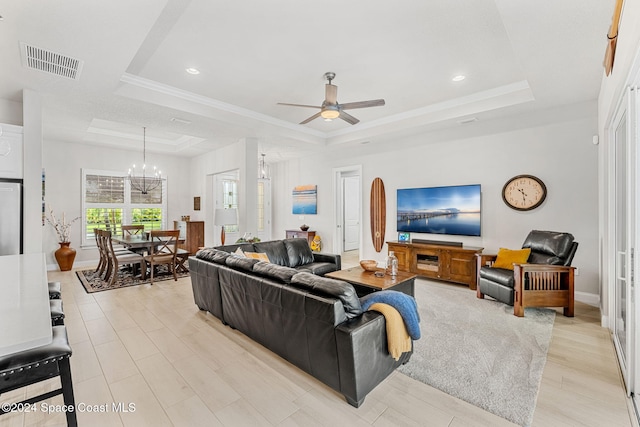 living room featuring light wood-type flooring, ceiling fan with notable chandelier, and a raised ceiling