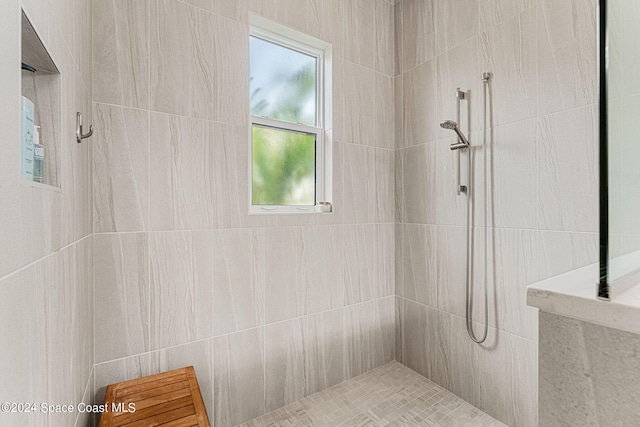 bathroom featuring tiled shower and plenty of natural light