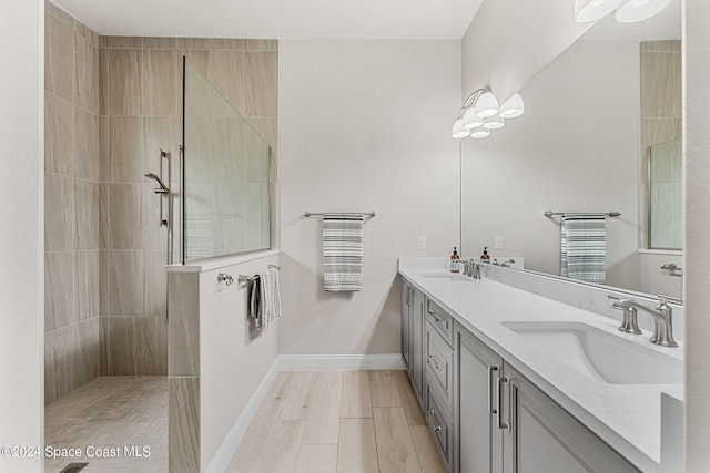 bathroom featuring vanity, hardwood / wood-style floors, and tiled shower