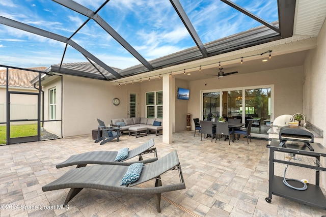 view of patio / terrace with outdoor lounge area, glass enclosure, and ceiling fan