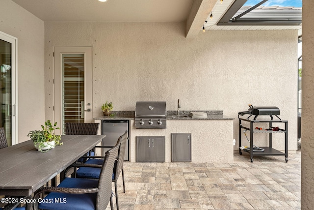 view of patio featuring sink, an outdoor kitchen, and a grill