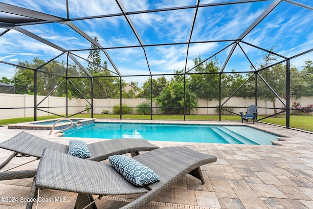 view of swimming pool with a patio, a lanai, and an in ground hot tub