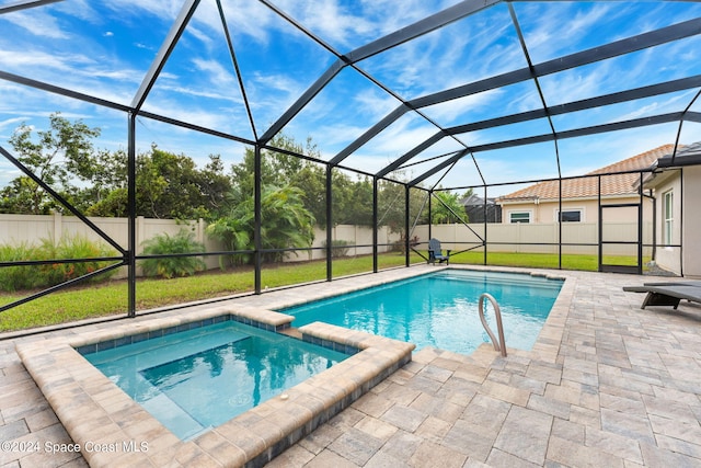 view of pool with a patio, a lanai, an in ground hot tub, and a lawn