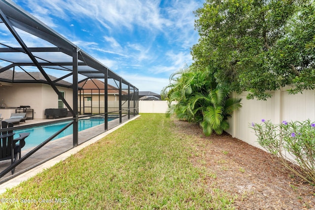 view of yard with a patio area, a fenced in pool, and a lanai