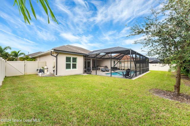 back of property featuring a fenced in pool, a patio area, a yard, and glass enclosure