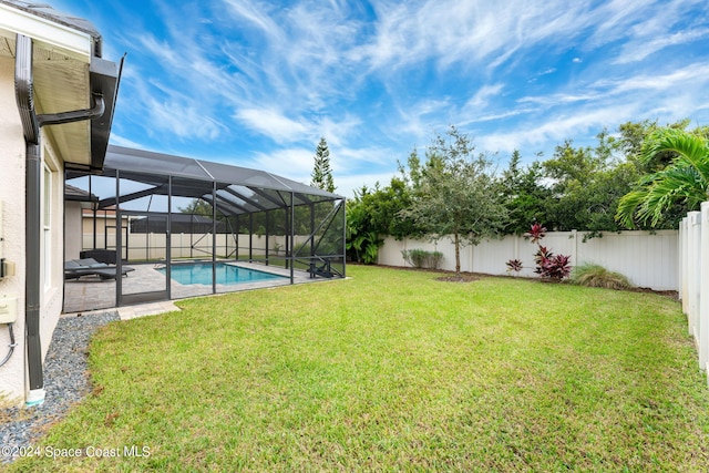 view of yard with a fenced in pool, a patio area, and a lanai