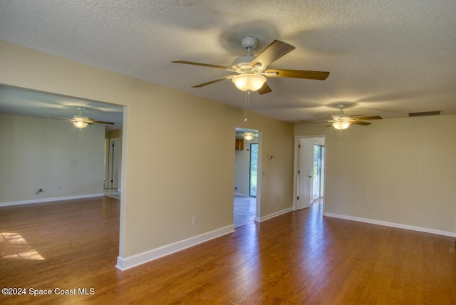 spare room with a textured ceiling, wood-type flooring, and ceiling fan