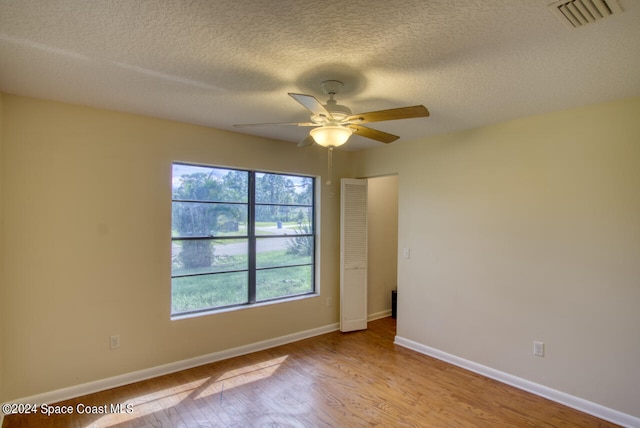 unfurnished room with light hardwood / wood-style flooring, a textured ceiling, and ceiling fan