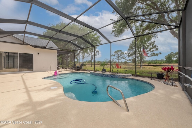 view of swimming pool with glass enclosure and a patio