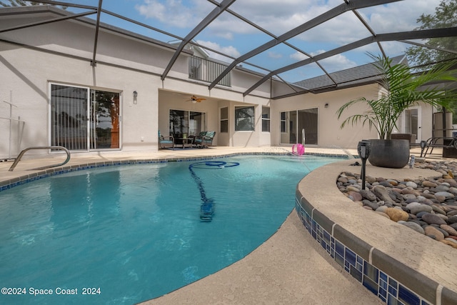 view of pool featuring ceiling fan, a lanai, and a patio area