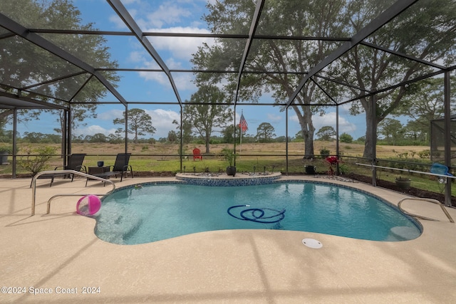 view of pool featuring glass enclosure and a patio area