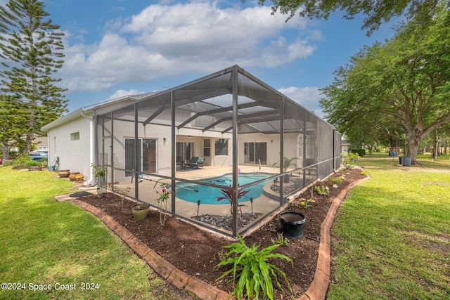 view of swimming pool featuring a yard, a patio area, and a lanai