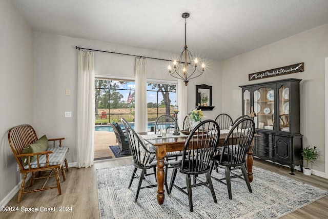 dining space with wood-type flooring and a notable chandelier