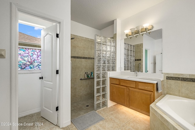 bathroom with plus walk in shower, tile patterned floors, vanity, and a textured ceiling