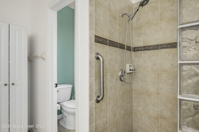 bathroom featuring a tile shower and toilet