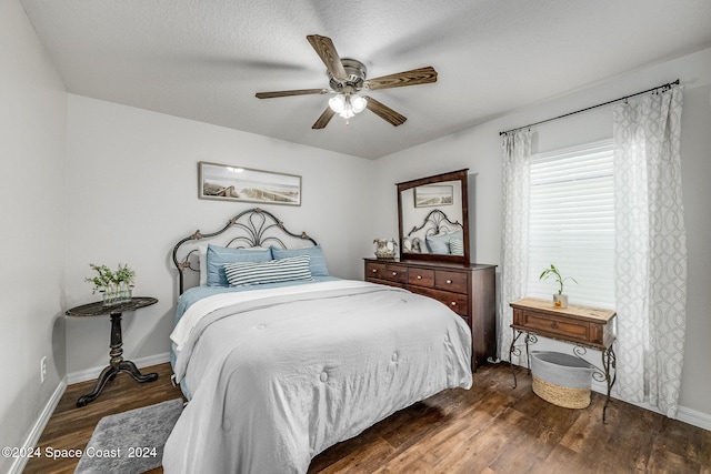 bedroom featuring ceiling fan, a textured ceiling, and dark hardwood / wood-style floors