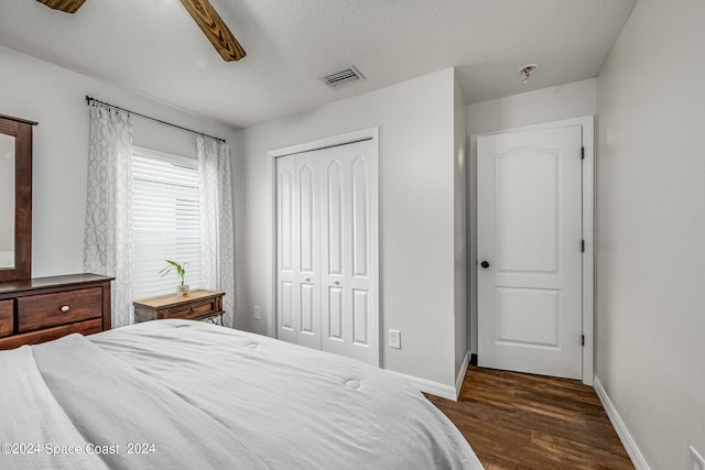 bedroom featuring ceiling fan, a textured ceiling, a closet, and dark hardwood / wood-style flooring